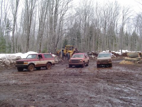 2000 Chevrolet Tahoe - Three SUVs navigate a muddy terrain with a bulldozer visible in the background.
