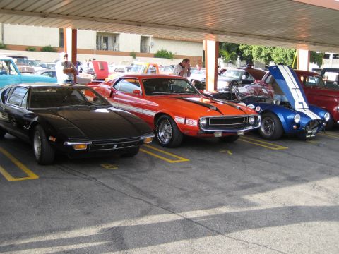 1968 Ford Mustang - A collection of vintage sports cars are parked in a covered lot, their distinctive designs.