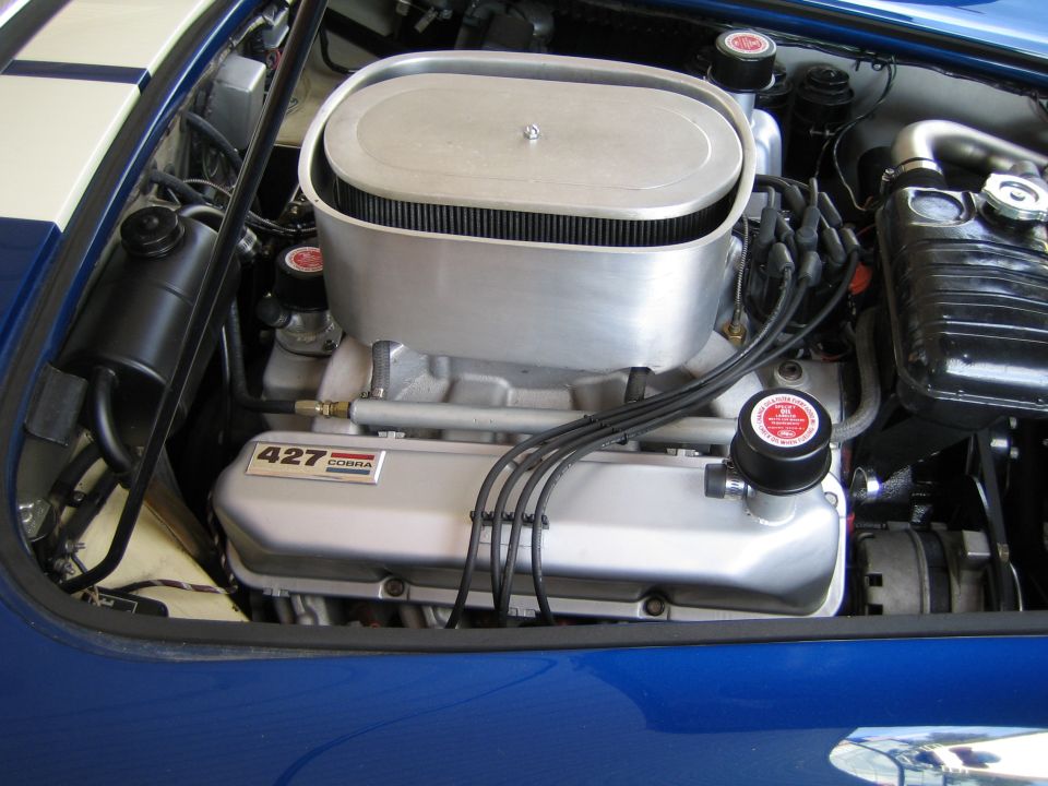 Close-up of a 427 Cobra engine with an oval air cleaner and blue valve covers