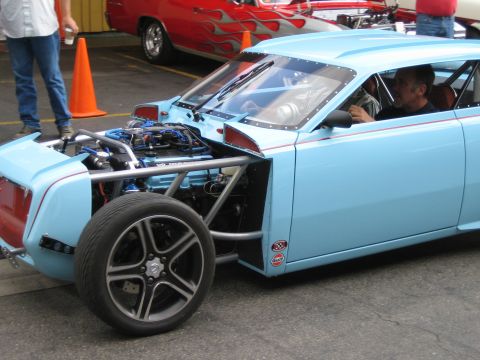 1968 Ford Mustang - A custom-built vehicle with a prominent engine and roll cage is parked outdoors.