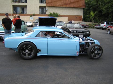 1968 Ford Mustang - A heavily modified light blue coupe with its hood open, revealing the engine and front suspension.