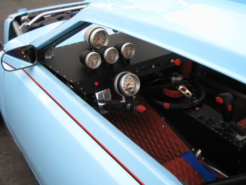1968 Ford Mustang - Interior view of a custom car, a dashboard filled with gauges and a racing-style steering wheel.