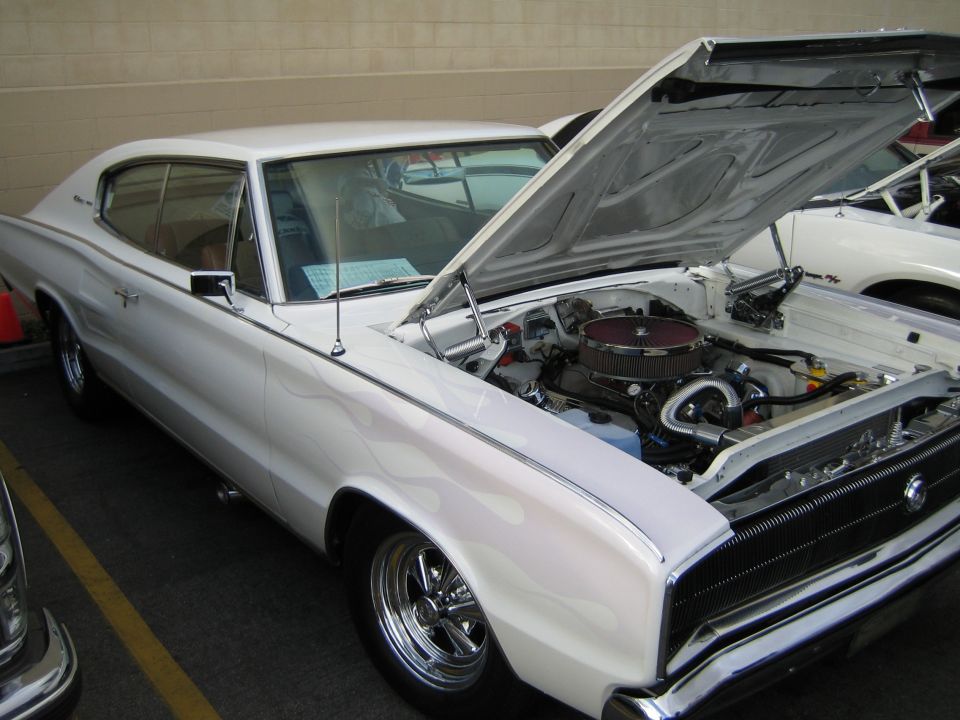 White Dodge Charger, hood open showing engine. Another white car is parked next to it