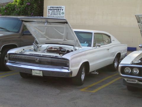 1968 Ford Mustang - A white 1966 Dodge Charger is parked with its hood open, revealing the engine bay.