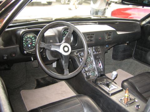 1968 Ford Mustang - The interior of a 1971 De Tomaso Pantera features a distinctive steering wheel and a dashboard filled with gauges.