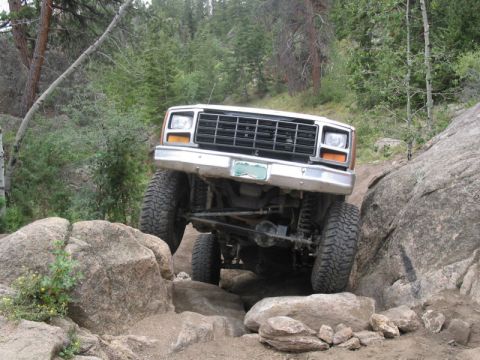 1981 Ford Bronco - This off-road SUV navigates a challenging rocky terrain on a dirt path.