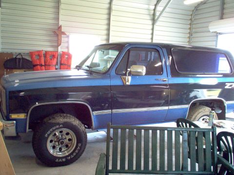 2004 Chevrolet Silverado 3500 - Two-tone blue and black SUV with chrome trim and aftermarket wheels.
