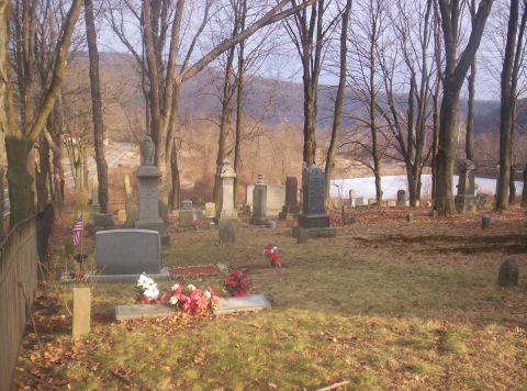1995 Ford Bronco - A cemetery scene with gravestones and trees under a cloudy sky.