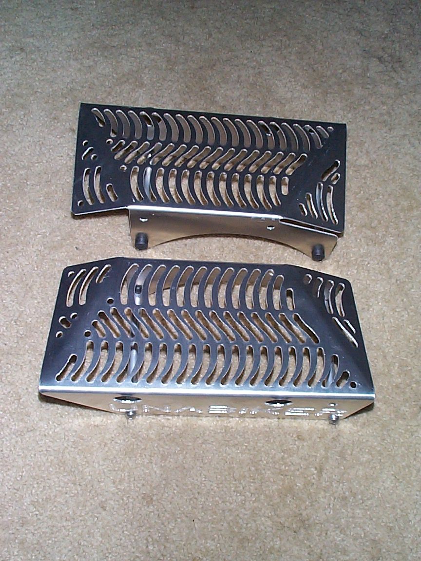Two silver motorcycle radiator guards with a bone-like pattern