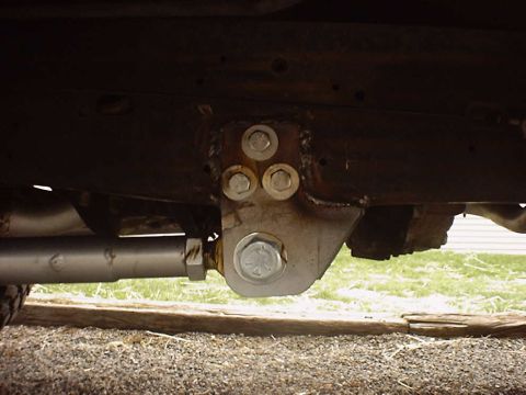 1988 Ford Bronco - A close-up view of a vehicle's suspension system, focusing on a bracket and bolts.