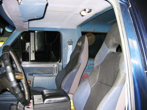 1985 Ford Bronco - The interior of the vehicle features custom bucket seats and a blue dashboard.