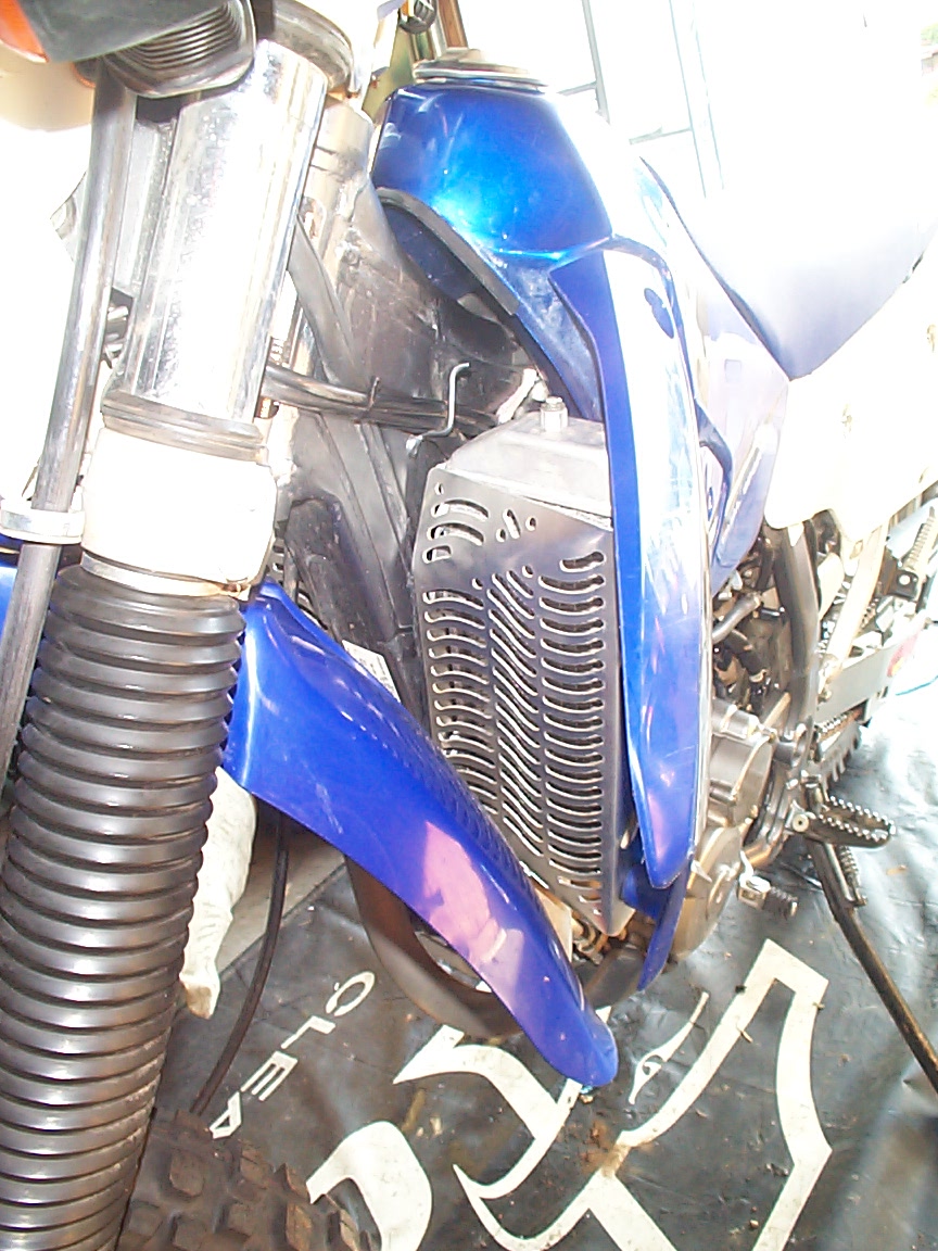 Blue motorcycle front section with radiator guard and ribbed fork boots