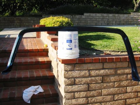 1985 Ford Bronco - A black metal frame, possibly a car part, is placed on brick steps and supported by a bucket.