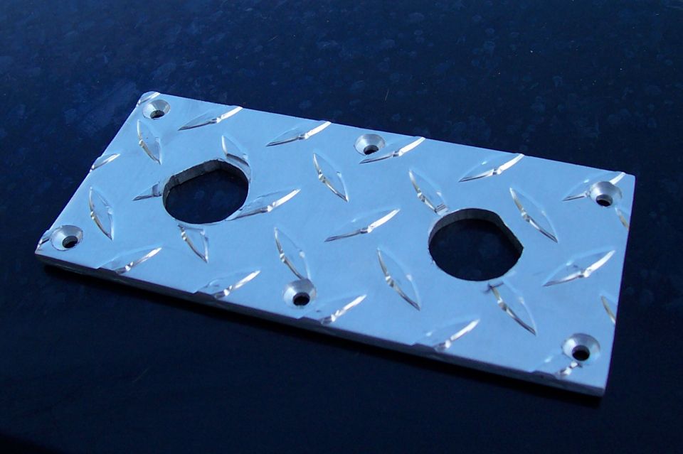 Polished aluminum diamond plate panel with two round cutouts and countersunk screw holes
