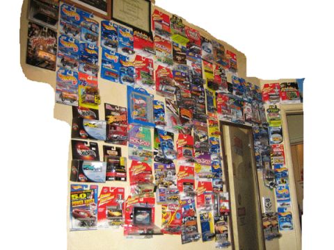 1968 Ford Mustang - A wall is covered with numerous packaged toy cars, creating a vibrant display of collectibles.