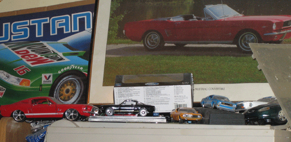 Collection of toy cars including a red Mustang and a black coupe