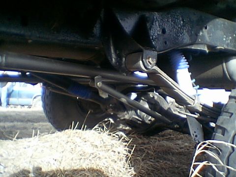 1979 Ford Bronco - The photo shows the undercarriage of a vehicle, focusing on the suspension components and leaf springs.