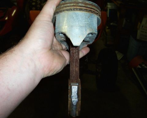 1994 Ford F-150 - Rusty engine piston and connecting rod assembly held in a hand.