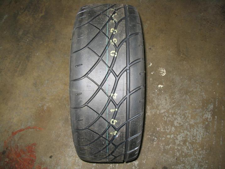 Tire with yellow markings on tread, on concrete floor
