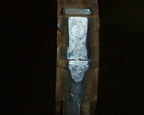 1994 Ford F-150 - A close-up view of a stamped metal component, showing alphanumeric markings.
