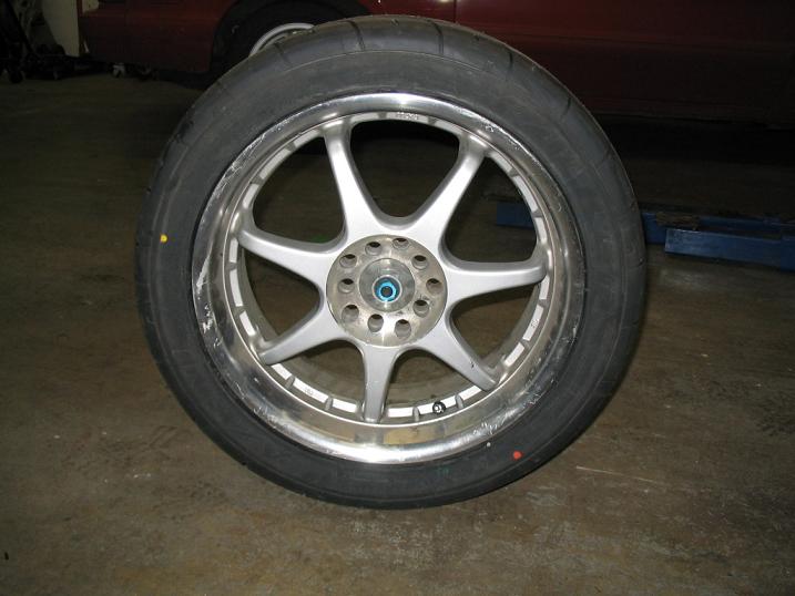 Silver 5-spoke wheel with a tire. Supermotors.net logo visible