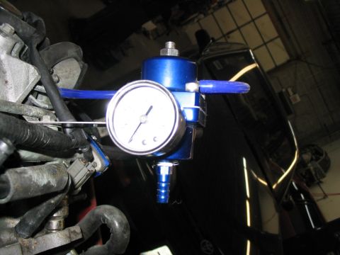 1993 Ford Probe - Close-up of a blue fuel pressure regulator with a gauge, connected to engine parts.
