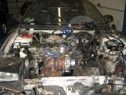 1993 Ford Probe - The engine bay of a 1993 Ford Probe is shown with a turbocharger installed.