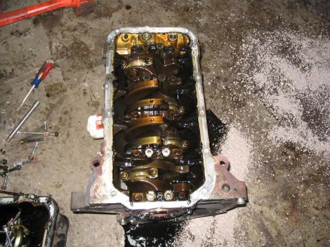 1993 Ford Probe - Disassembled engine block with crankshaft visible, surrounded by tools and debris on a concrete floor.
