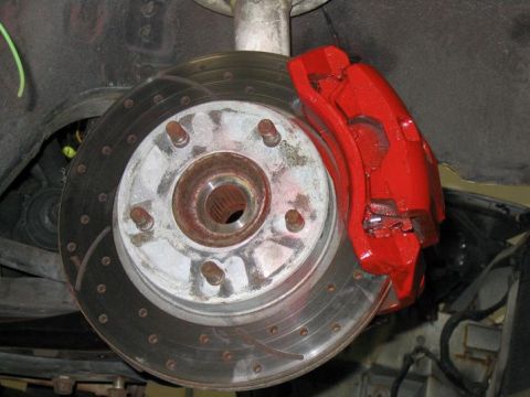 1993 Ford Probe - Close-up of a car's front brake assembly, showing a red caliper and a vented rotor.