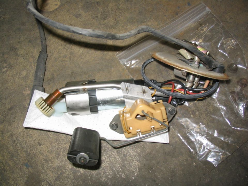 Fuel pump assembly with float arm and electrical connectors on a white cloth