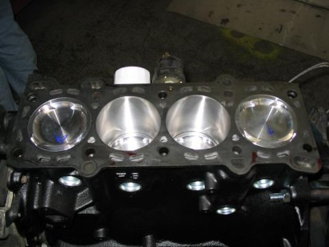 1993 Ford Probe - Engine block with pistons and gasket. This is a part of a vehicle's engine.