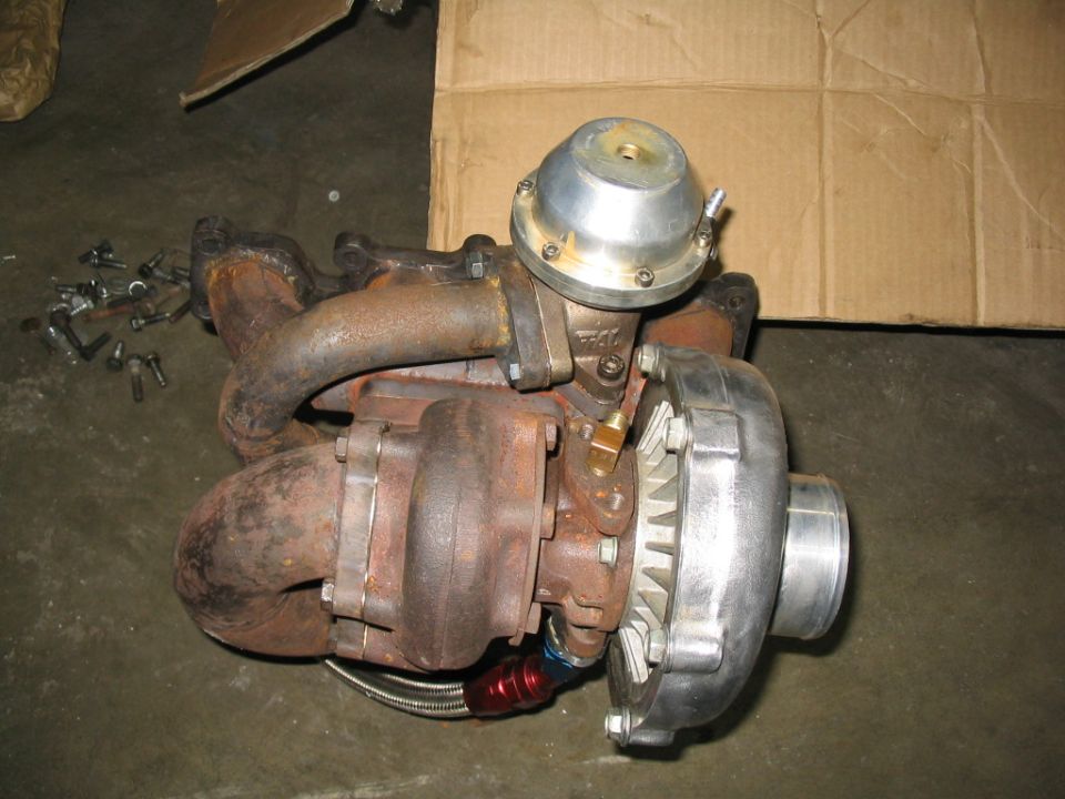 Turbocharger with wastegate and braided oil line