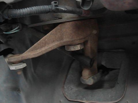 1989 Ford Bronco - A close-up view of a rusted suspension part, likely from the underside of a vehicle.
