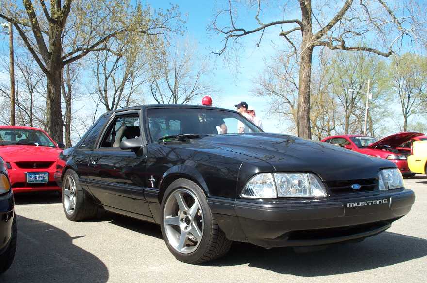 Black Fox-body Mustang notchback coupe with roof beacon at a car show