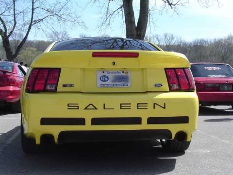 1998 Ford Crown Victoria - Rear view of a yellow Saleen Mustang, parked next to a red car. Kentucky license plate is on the yellow car.