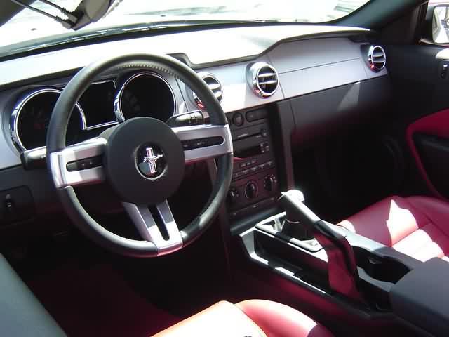 S197 Ford Mustang interior with red leather seats, aluminum dash trim, and manual shifter