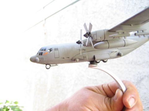 1968 Ford Mustang - Model airplane held by hand, showing a C-130 Hercules with propellers and landing gear.