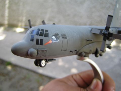 1968 Ford Mustang - A hand holds a model of a C-130 Hercules aircraft, a distinctive nose art decal.