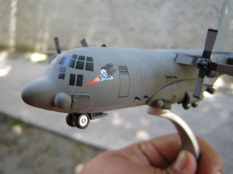 Close-up of a gray model airplane with a skull and crossbones decal on its side