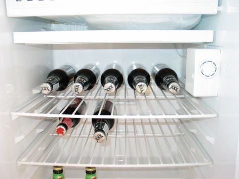 1995 Ford Bronco - Bottles of beer stored on wire shelves inside a refrigerator unit.