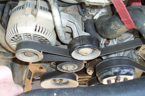 1994 Ford F-150 - The serpentine belt system in a vehicle's engine bay is shown in this close-up view.
