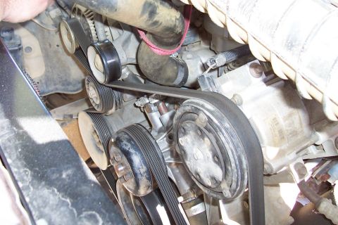 1994 Ford F-150 - Close-up view of engine belts and pulleys, showing the serpentine belt system and AC compressor.
