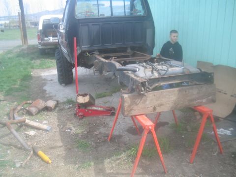 1983 Ford F-250 - The rear section of a truck is disassembled, with the frame and fuel tank supported by sawhorses.