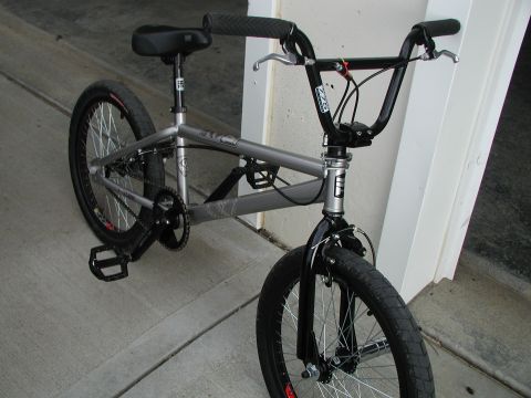 1998 Jeep TJ - A silver BMX bicycle is parked on a concrete surface, leaning against a wall.