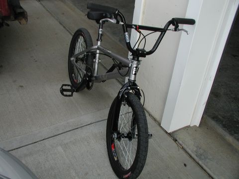 1998 Jeep TJ - BMX bicycle parked on concrete near a white wall.