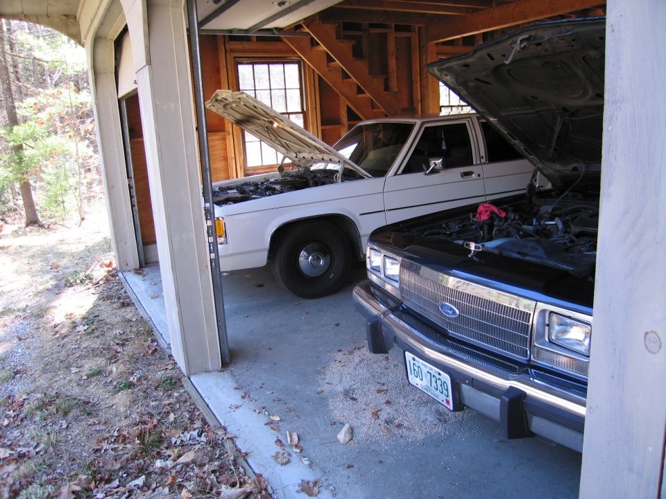 Front view of a 1991 Ford Crown Victoria LTD with hood open, parked next to another car