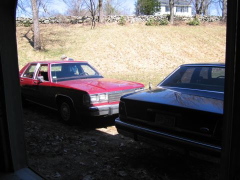 1991 Ford LTD Crown Victoria - A red 1991 Ford Crown Victoria LTD is parked next to another sedan in a driveway.
