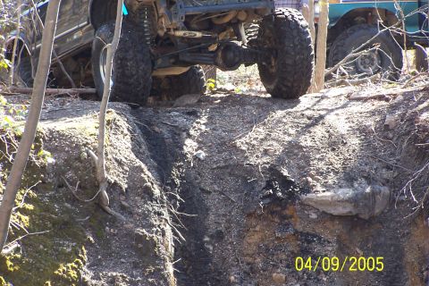1979 Ford Bronco - Off-road vehicles tackle a challenging rocky terrain, with one vehicle partially obscured in the background.