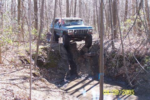 1979 Ford Bronco - This 1979 Ford Bronco tackles a challenging off-road obstacle in a wooded area.