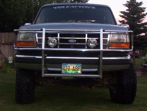 1994 Ford Bronco - This Ford truck features a prominent chrome grille guard and auxiliary lights, with a license plate visible.